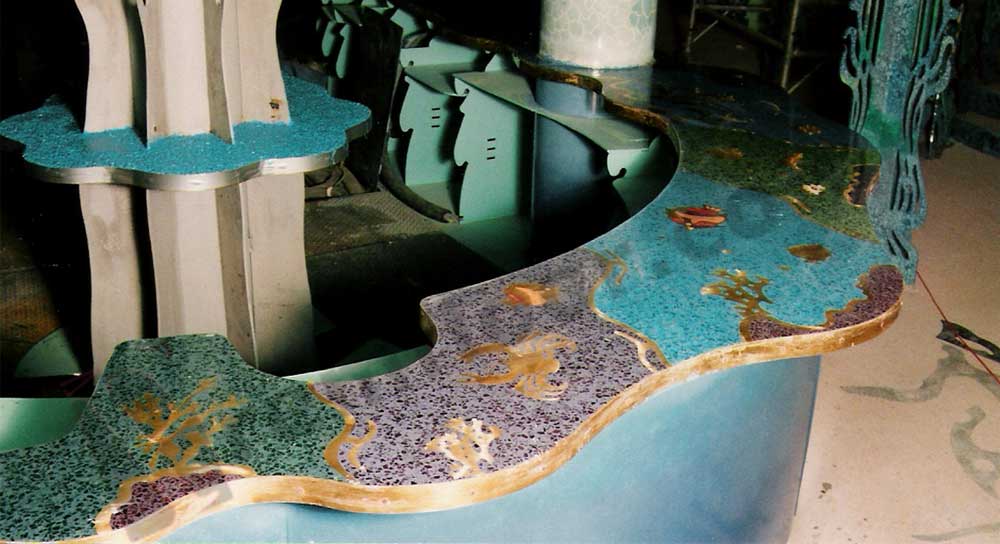 Bar in nightclub with blue resin terrazzo countertop featuring sea creatures and underwater creatures